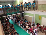 Imagem de uma sala organizada como um auditório com diversas pessoas reúnidas na plateia