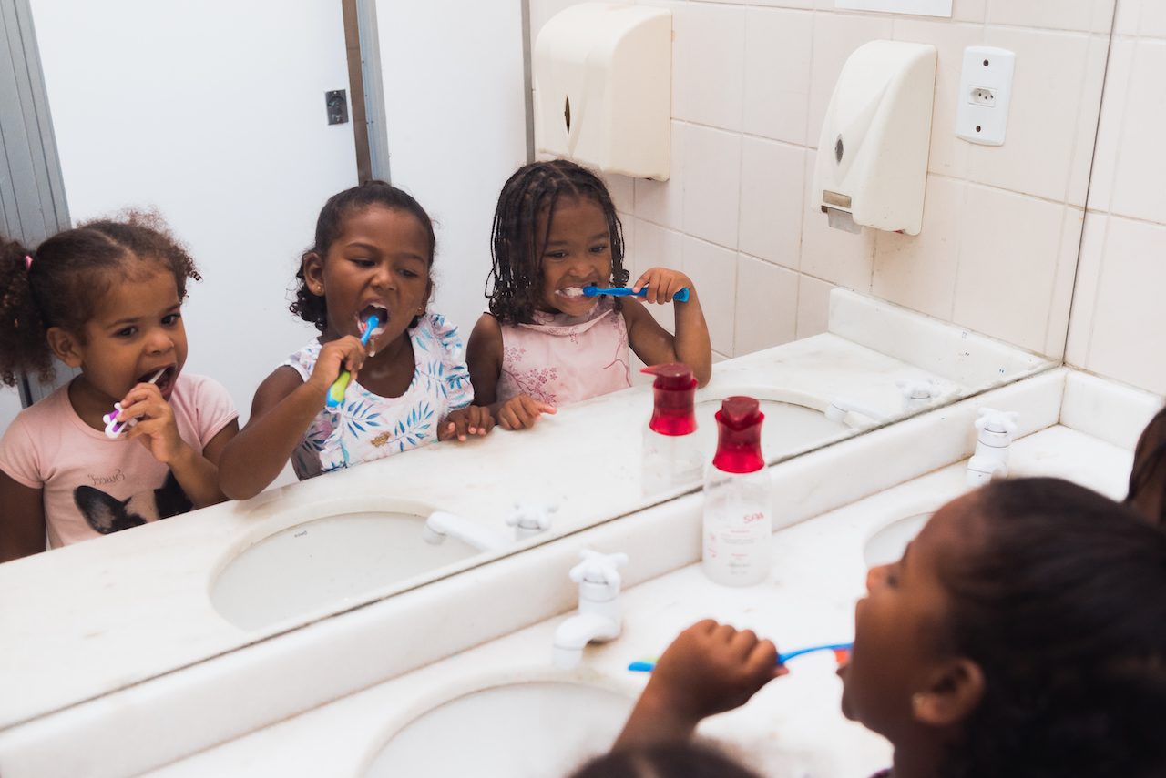 Três meninas escovando os dentes