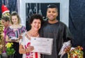 Um homem de toga e uma mulher segurando um certificado